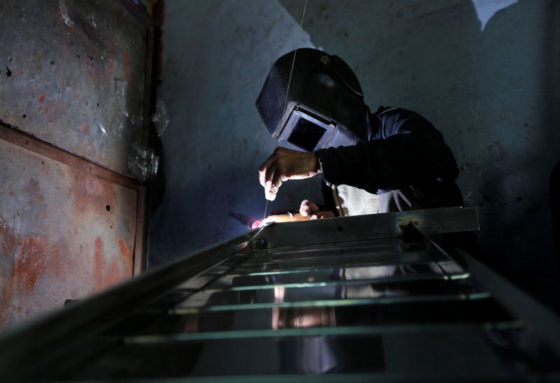 © Reuters. A worker welds steel pipes to make a counter at a steel furniture manufacturing unit in Ahmedabad