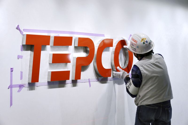 &copy; Reuters. A worker puts up new logo of TEPCO in Tokyo