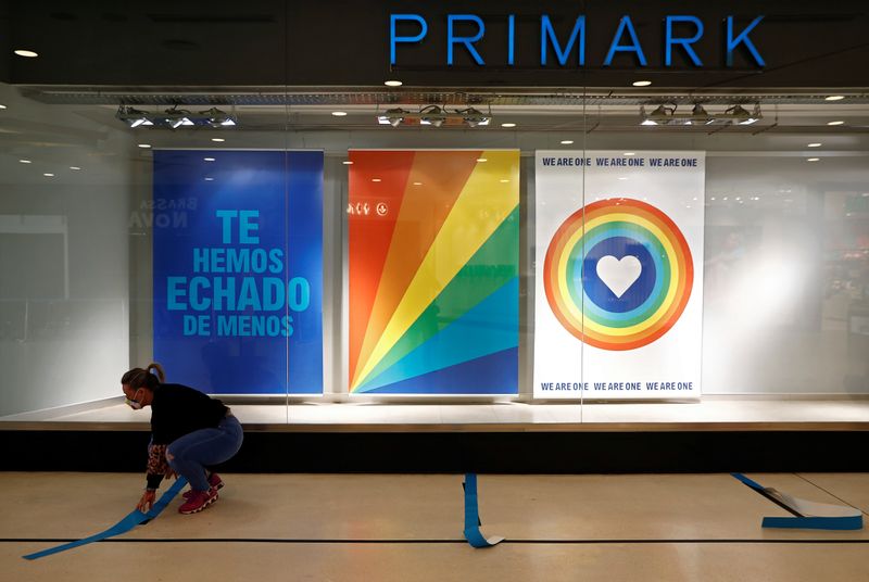 &copy; Reuters. FOTO DE ARCHIVO. Una trabajadora de Primark instala marcas para promover la distancia física antes de la reapertura de la tienda tras la cuarentena por la pandemia del coronavirus (COVID-19), en Madrid, España