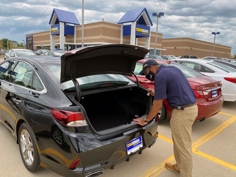 © Reuters. Brandon Parrum, general manager of CarMax's Des Moines store, shows off one of the many vehicles that customers can arrange to buy online and collect at the store