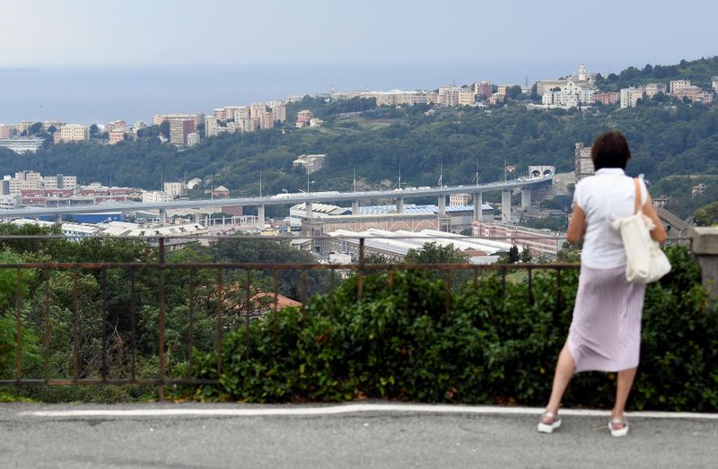 &copy; Reuters. Una donna osserva il nuovo Ponte di Genova in attesa della sua inaugurazione ufficiale, dopo quasi due anni di lavori per sostituire il Ponte Morandi, crollato il 14 agosto 2018, uccidendo 43 persone.