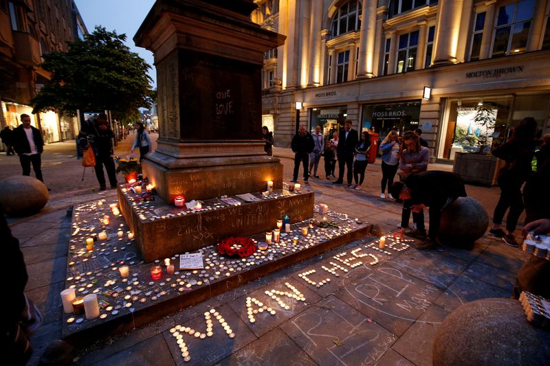 © Reuters. FILE PHOTO: People attend a vigil for the victims of last week's attack at a pop concert at Manchester Arena, in central Manchester