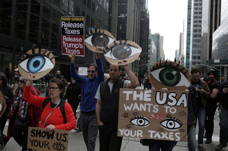 © Reuters. FILE PHOTO: People march demanding U.S. President Donald Trump release his tax returns, in New York