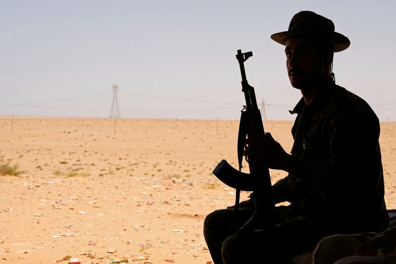 © Reuters. A member of the Libyan National Army (LNA) commanded by Khalifa Haftar sits in a tent at one of their sites in west of Sirte