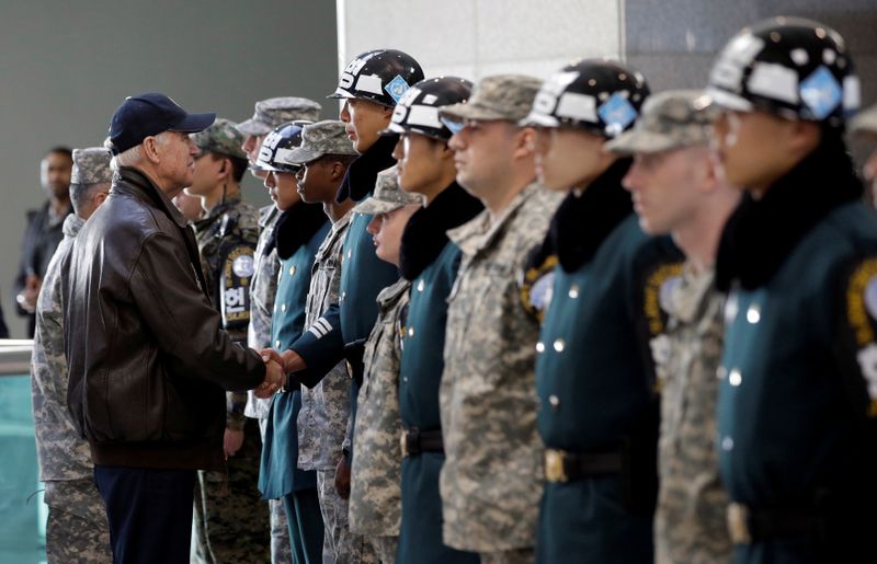 © Reuters. FILE PHOTO: U.S. Vice President Joe Biden shakes hands with South Korean and U.S. soldiers during a tour of the DMZ, the military border separating the two Koreas, in Panmunjom