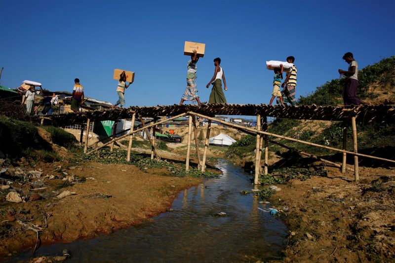 &copy; Reuters. FILE PHOTO: Rohingya refugees carry supplies at Kutupalong refugee camp, near Cox&apos;s Bazar