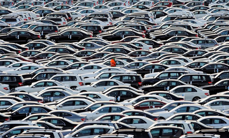 &copy; Reuters. A worker walks along rolls of Mercedes cars at a shipping terminal in the harbor of the town of Bremerhaven