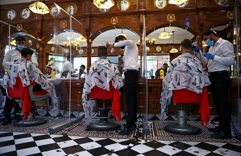 © Reuters. Homens cortam cabelo em reabertura em Londres após paralisações devido ao coronavírus