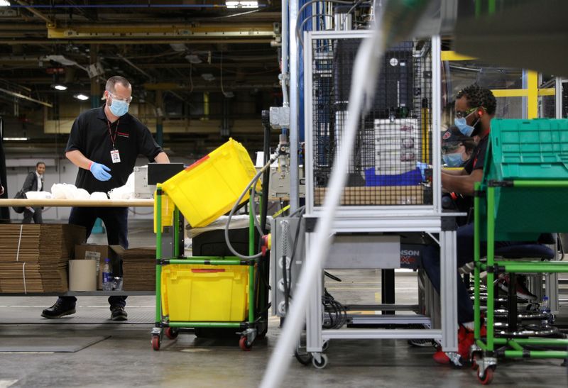 © Reuters. FILE PHOTO: Workers make protective face masks as U.S. President Donald Trump visits Honeywell plant in Phoenix, Arizona