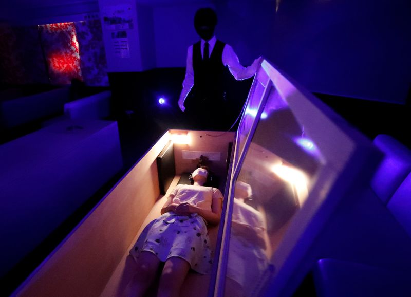 &copy; Reuters. A participant lies inside a mock of coffin with plastic shields to maintain social distancing amid the spread of the coronavirus disease (COVID-19), during a coffin horror show, in Tokyo