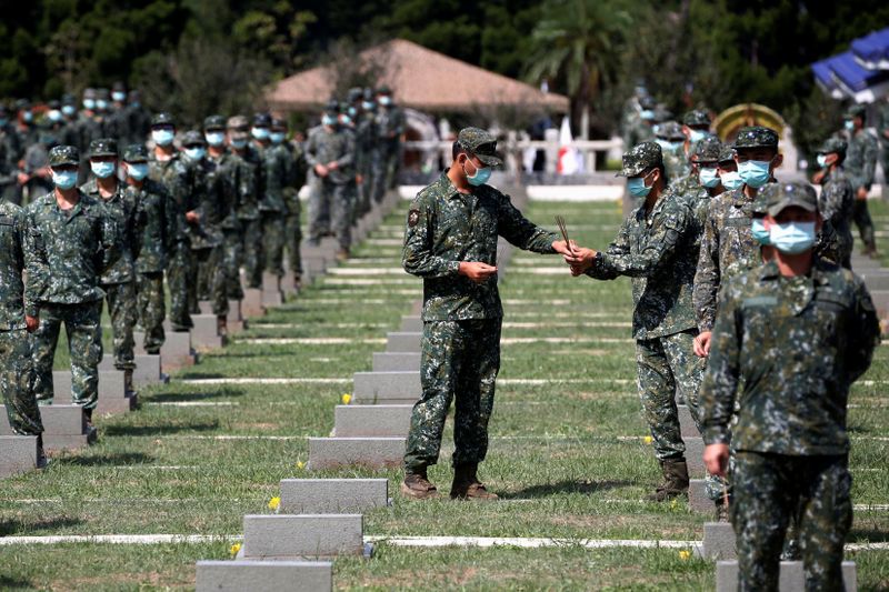 © Reuters. Soldiers pass incense to each other to pay respects to the deceased, during an event to mark the 62nd anniversary of the Second Taiwan Strait crisis in Kinmen, Taiwan