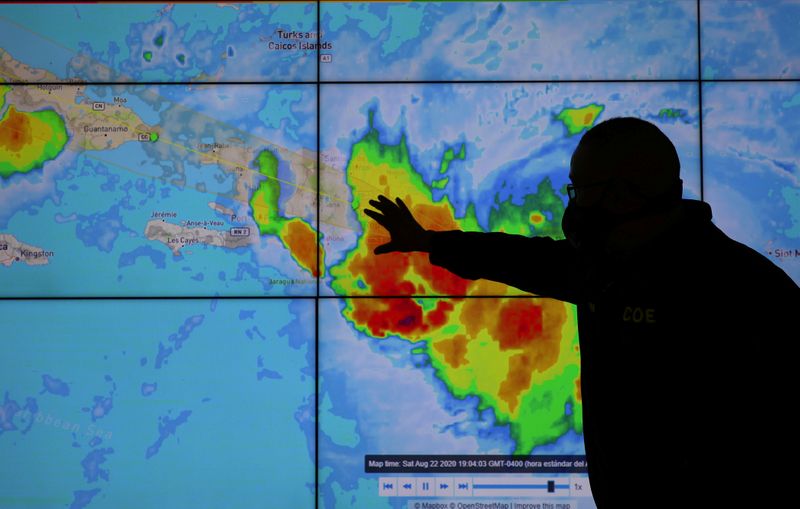 &copy; Reuters. Un miembro del Comité de Operaciones de Emergencia mira la trayectoria de la tormenta Laura en Santo Domingo, República Dominicana.