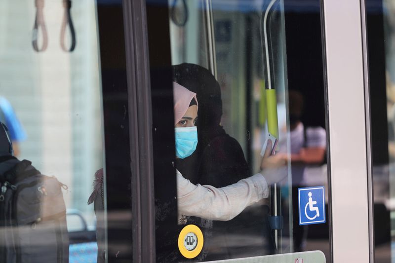 &copy; Reuters. FILE PHOTO: A passenger wearing a protective mask is seen through a window as she travels on the light rail in Jerusalem amid the spread of the coronavirus disease (COVID-19)