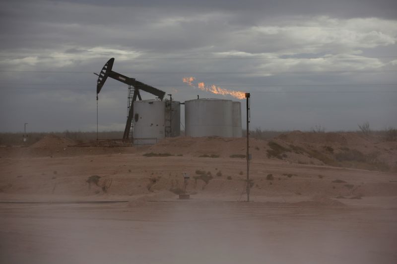 &copy; Reuters. FILE PHOTO: Dust blows around a crude oil pump jack and flare burning excess gas at a drill pad in the Permian Basin in Loving County