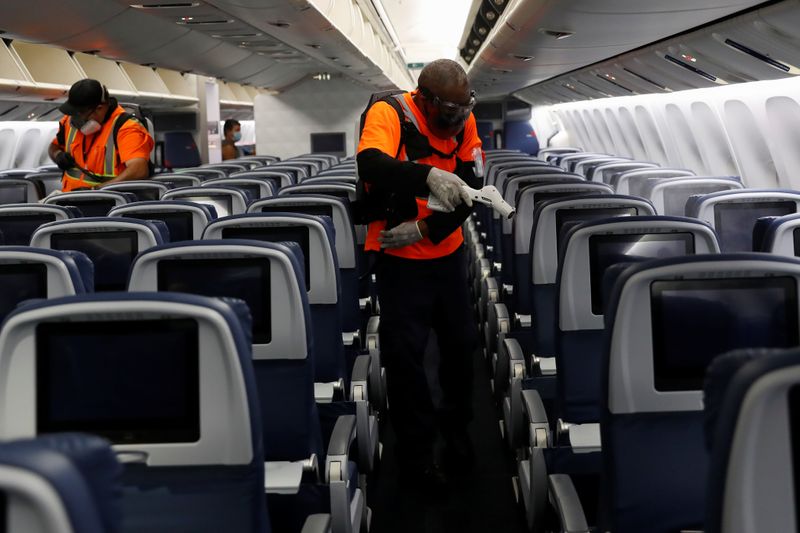 &copy; Reuters. Delta Airlines pre-flight cleaning crew members use electrostatic disinfection devices to clean an aircraft at JFK International Airport in New York