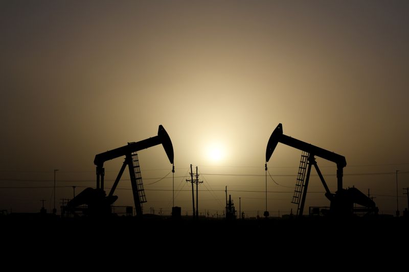 © Reuters. FILE PHOTO: Pump jacks operate at sunset in Midland