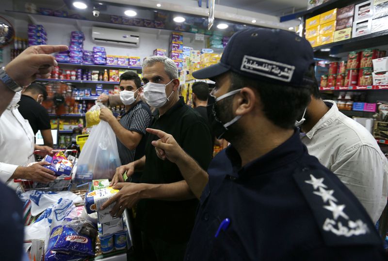 &copy; Reuters. Palestinos fazem compras em mercado de Gaza após confirmação de primeiros casos de Covid-19