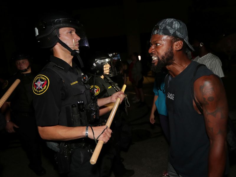 &copy; Reuters. Homem confronta policial do lado de fora do Departamento de Polícia de Kenosha, em Wisconsin