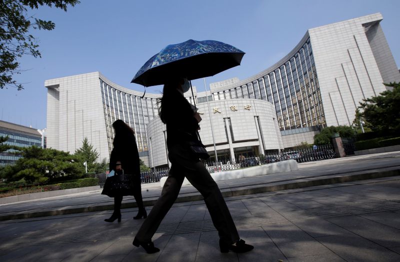 &copy; Reuters. People walk past the headquarters of the PBOC, the central bank, in Beijing