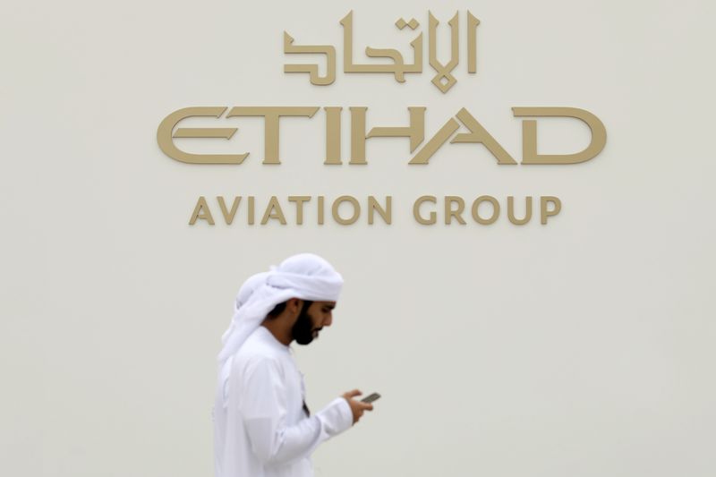 &copy; Reuters. FILE PHOTO: A visitor walks past the Etihad Aviation Group logo on display during the fifth day of Dubai Air Show in Dubai