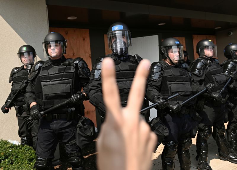 &copy; Reuters. Adam Andrew Salgado sostiene un cartel mientras la policía mantiene un perímetro en Kenosha, Wisconsin, EEUU, el 24 de agosto de 2020