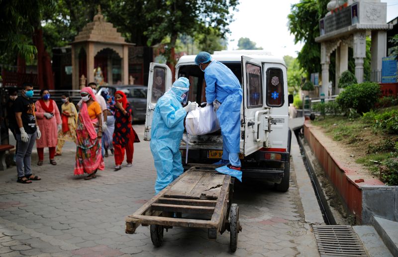 &copy; Reuters. FOTO DE ARCHIVO: Varios trabajadores portando equipos de protección sanitarios recogen el cadáver de una víctima del coronavirus en Nueva Delhi