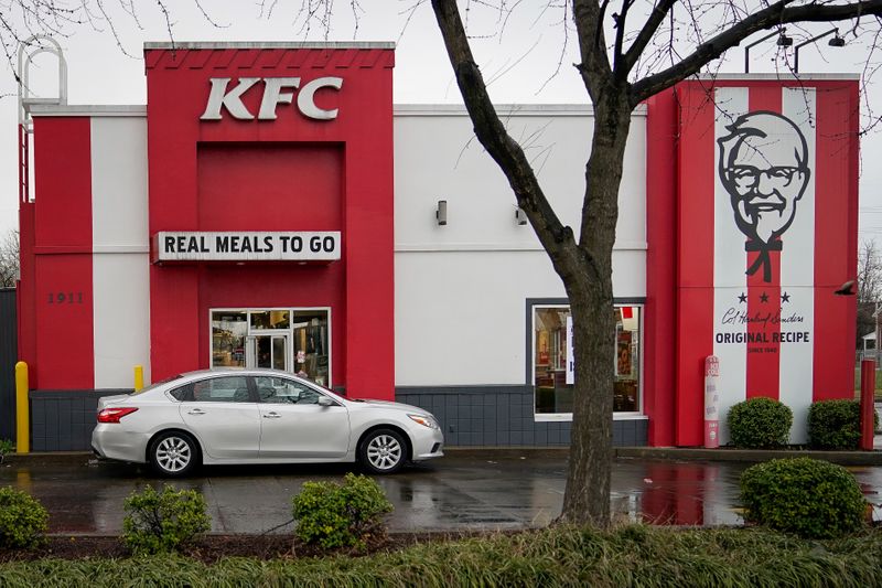 © Reuters. FILE PHOTO: A vehicle waits at the drive-thru window of Kentucky Fried Chicken after a state mandated carry-out only policy went into effect in order to slow the spread of the novel coronavirus (COVID-19) in Louisville