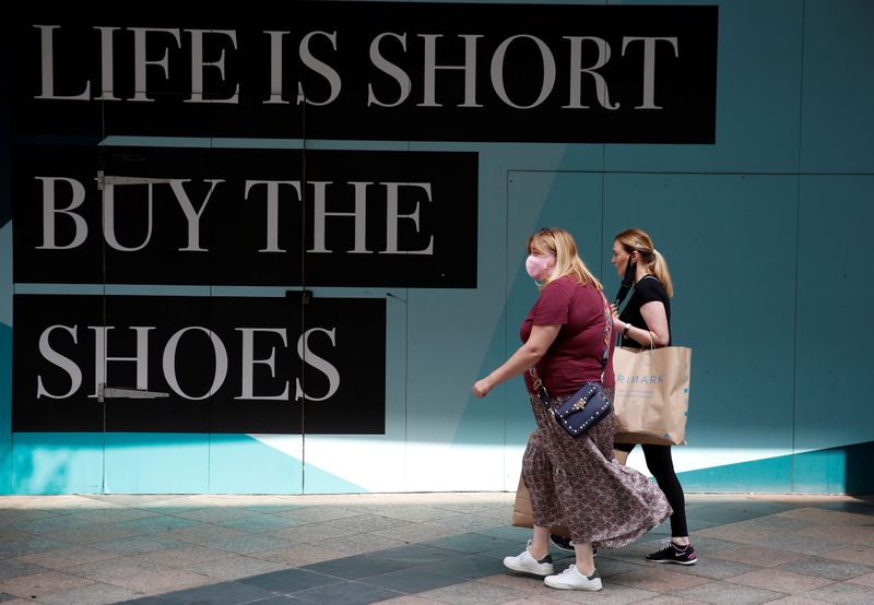 © Reuters. FILE PHOTO: People walk past a closed retail unit following the outbreak of the coronavirus disease (COVID-19) in Warrington