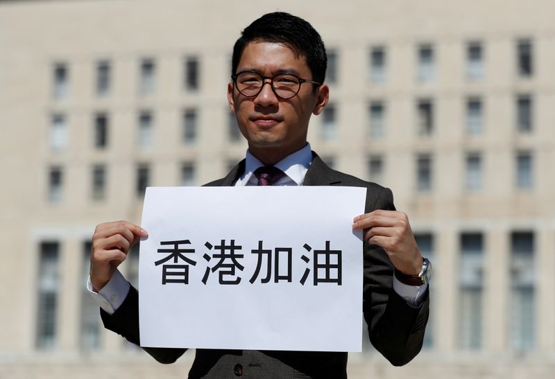 © Reuters. Exiled Hong Kong pro-democracy activist Nathan Law holds a placard outside the Italian Foreign Ministry in Rome