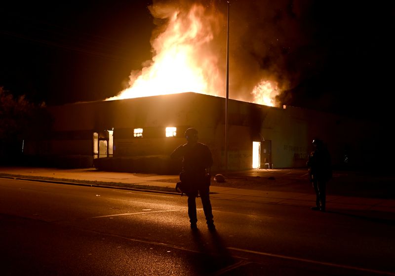 © Reuters. People protest after a Black man identified as Jacob Blake was shot several times by police in Kenosha