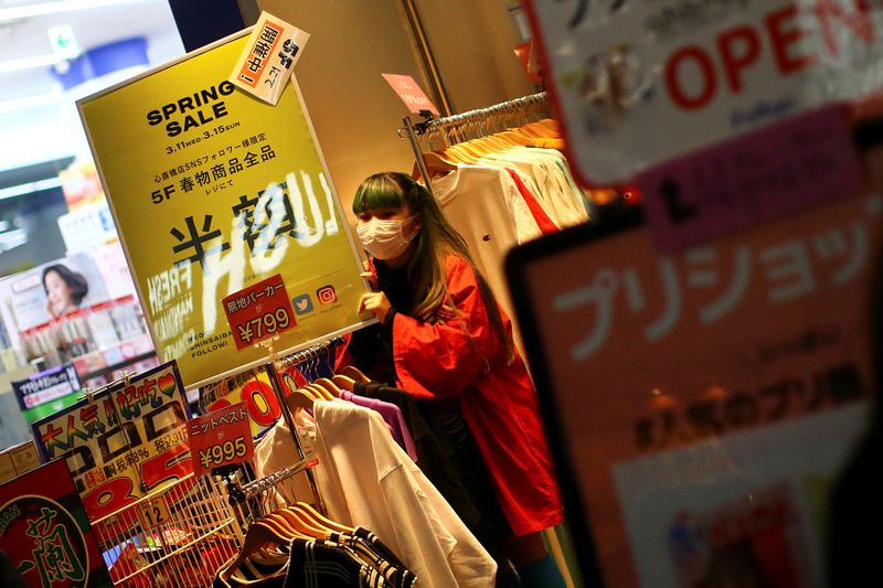 © Reuters. A vendor, wearing a protective mask following an outbreak of the coronavirus disease (COVID-19), offers merchandise on an almost empty street in the Dotonbori entertainment district of Osaka