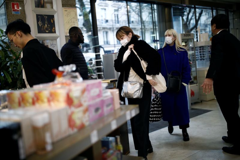 &copy; Reuters. Tourist wearing protective masks enter a duty free shop in Paris as the country is hit by the new coronavirus
