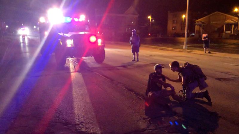 &copy; Reuters. A man wounded during a protest following the police shooting of Jacob Blake, a Black man, sits on a street in Kenosha