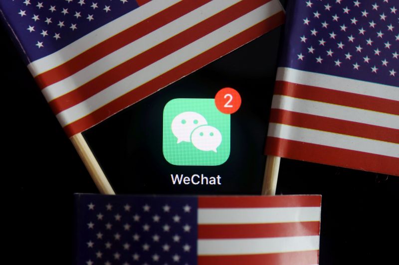 © Reuters. FILE PHOTO: The messenger app WeChat is seen among U.S. flags in this illustration picture