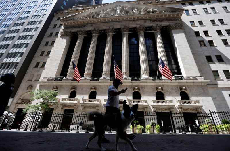 &copy; Reuters. A man walks a dog in the shade past the New York Stock Exchange (NYSE) during hot weather in New York