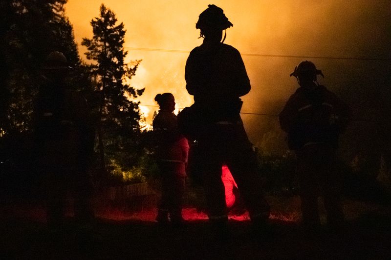 &copy; Reuters. Santa Rosa firefighters monitor the LNU Lightning Complex Fire from a neighboring hilltop in Healdsburg, California