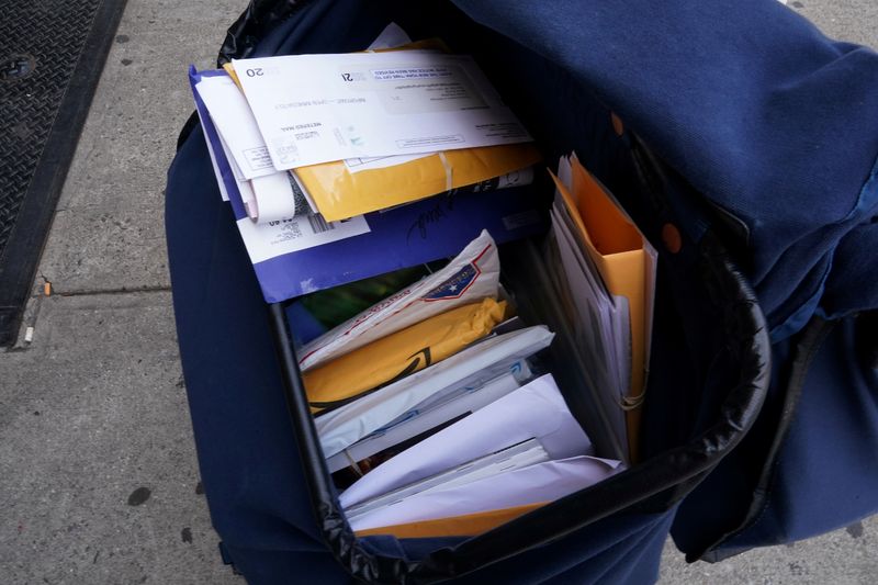 © Reuters. FILE PHOTO: Mail is seen in the bag of a U.S. Postal Service (USPS) worker as he delivers mail