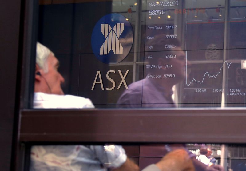 &copy; Reuters. A pedestrian is reflected in a window where an investor sits looking at a board displaying stock prices at the Australian Securities Exchange in Sydney