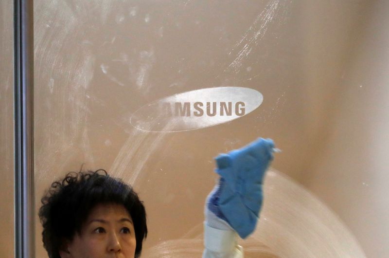 &copy; Reuters. A worker wipes a glass panel bearing the logo of Samsung Electronics at its office building in Seoul
