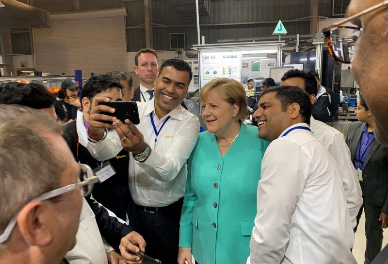 © Reuters. FILE PHOTO: German Chancellor Angela Merkel visits Continental Automotive Components India Pvt Ltd plant at Manesar