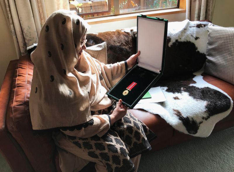 © Reuters. FILE PHOTO: Ambreen Naeem holds a medal which was posthumously awarded to her husband Mian Naeem Rashid for bravery, after being killed charging the attacker at an attack on Al Noor mosque in March in Christchurch, New Zealand