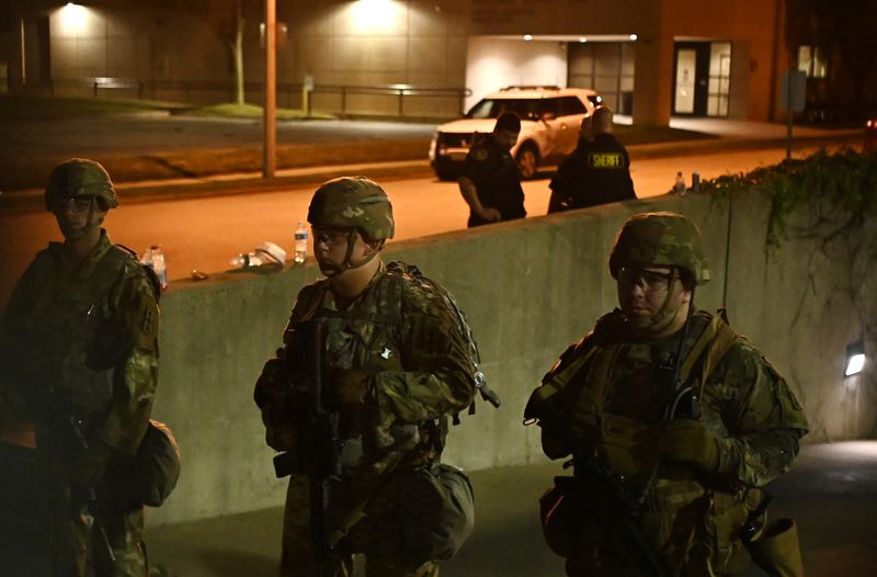 © Reuters. Members of the Wisconsin National Guard keep watch at their post behind the Kenosha Police Department building following the police shooting of Jacob Blake, a Black man, in Kenosha