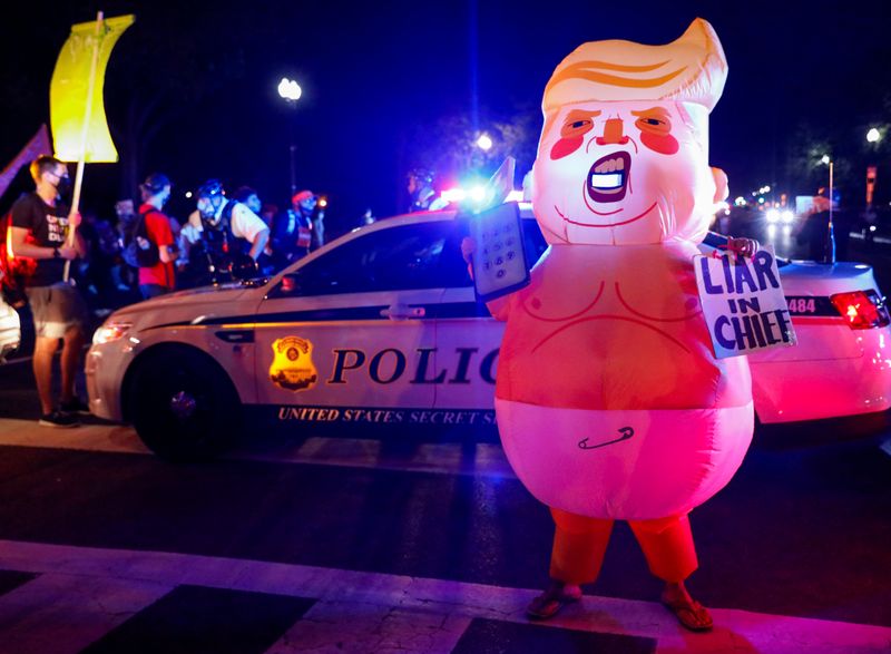 © Reuters. An inflatable costume depicting U.S. President Donald Trump as a baby is pictured during a protest as security officers block the path on Constitution Avenue in Washington