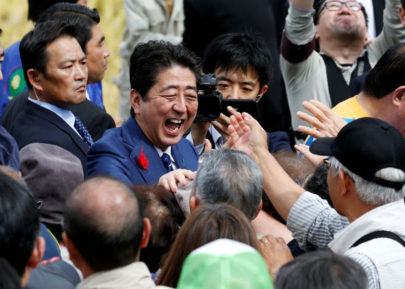 © Reuters. FOTO DE ARCHIVO: El primer ministro de Japón, Shinzo Abe, da la mano a sus partidarios después de un mitin electoral en Fukushima, Japón, el 10 de octubre de 2017