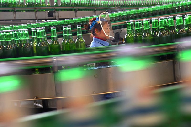 &copy; Reuters. Woman works at the production line at a beer factory in Zibo, Shandong