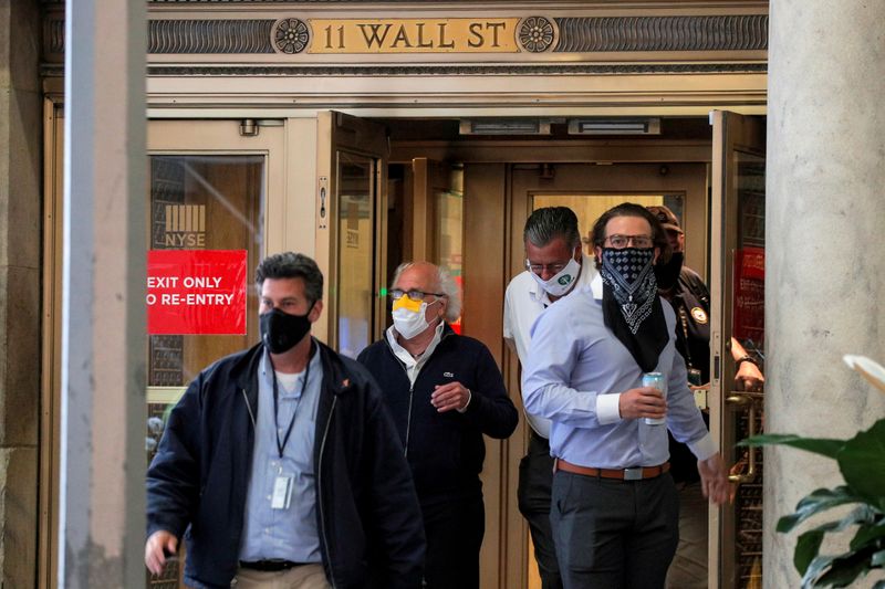 &copy; Reuters. Трейдеры в масках выходят из здания Нью-Йоркской фондовой биржи