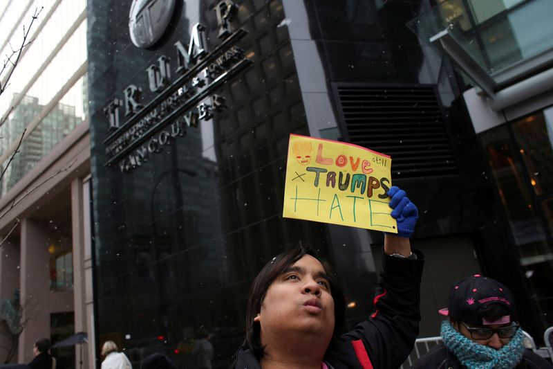 © Reuters. FILE PHOTO: Protester Henry Ho holds a sign during the grand opening of the Trump International Hotel and Tower in Vancouver