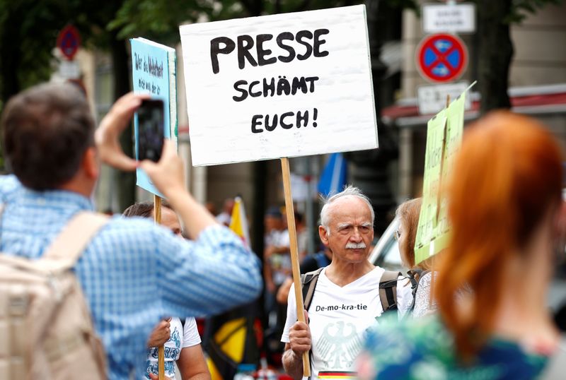 &copy; Reuters. Un hombre sostiene una pancarta que dice &quot;Prensa, vergüenza&quot; en la Puerta de Brandenburgo en Berlín, Alemania, el 29 de agosto de 2020