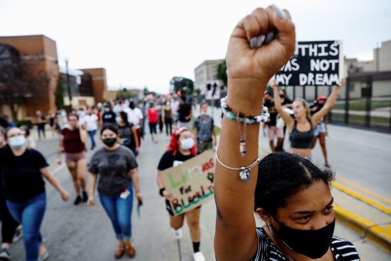 &copy; Reuters. A woman reacts with a raised fist while marching with others, following the police shooting of Jacob Blake, a Black man, in Kenosha, Wisconsin