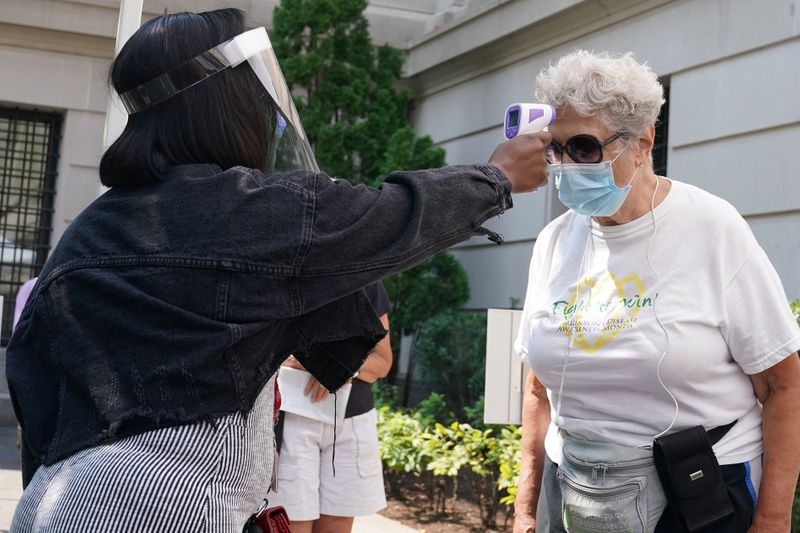 &copy; Reuters. FILE PHOTO: A woman has her temperature checked before attending The Metropolitan Museum of Art on their first day open since closing due to the coronavirus disease (COVID-19) outbreak